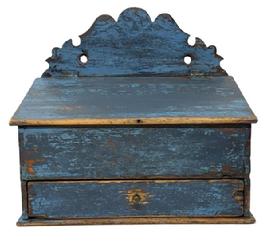 M1111 Early 19th century blue painted wall box with decoratively cut out back, hinged lid and drawer below. The old blue paint is over its original paint decorated surface.  Dovetailed case and drawer � with both having divided interiors. Small square head nail construction. Circa 1840�s. Measurements: 12 &frac34;� wide x 7 &frac34;� deep x 6 &frac12;� tall (front) x 14� tall (back).