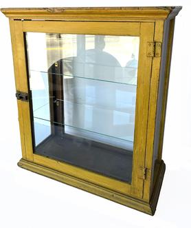 T120 This Display Cabinet sat on the counter of an old general store in the late 1800�s or early 1900�s. The wood is pine, with beautiful yellow paint, with a glass front, sides and back. It has straight sides and good visibility with the glass in the back that allows light in. The back door is hinged for easy access to the interior. It would make a fine case for displaying small toys or tins or any other items which deserve showcasing.  Measurements: 22� wide x 25� tall x 10 ½� deep