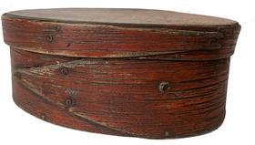 F38 mid-19th century. Bentwood construction having tacked lap joints. Oval pantry box in the original dry red paint with finger laps.