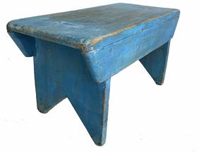 G222  Blue painted stool with boot jack cut out feet. The legs are mortised through the top. Double sided apron has tapered ends with rounding to smooth the edges of apron ends, ends of the top, and inside the boot jack cut out.  Measurements: 16 1/2� wide x 7 1/4� deep x 7 1/2� tall 