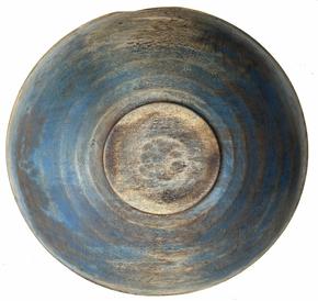 H498 Late 18th century New England original blue painted large Beehive wooden bowl. It is out of round. Bold form with lipped rim tapering subtly downward, showing strong evidence of slow lathe turnings and rests on slightly raised foot.  The natural patina interior shows typical minor abrasions and chop marks from years of use. Measurements: 16 ½� x 17 ¼� x 4 ½� tall. Footed area measures: 5 ¼� x 5�