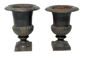 M182 Two small, heavy cast iron garden flower urns bearing their old black painted surfaces. These are very similar; however, they are not an exactly matched pair. Measurements: both are 7 top diameter and rest on 3 ¾ square bases; with one being 9 tall and the other being 8 ½ tall.