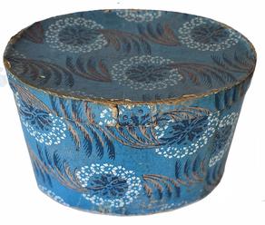 G465 BANDBOX. American, late 18th-early 19th century. Cardboard covered with floral blue wallpaper. Interior lined with newspaper including and add for Portland Maine 1844. Measures 12.5"h. 17.5"w.