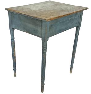 J418 New England original blue painted table with Sheraton-style turned legs that are mortised into the apron. Square head nail construction. The overhang on the top is only on three-sides as it was used to sit flush against a wall. Circa 1870�s. Measurements: 23 ¾� wide x 18 ½� deep x 28 ¼� tall 