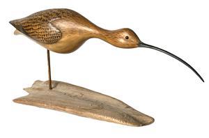 K224 Hand Carved and Painted Curlew Shorebird Decoy signed and branded on bottom of base E. Stough. Decoy features defined tail and wings with glass eyes and a long, downward curved wooden bill. Carver utilized a piece of driftwood for the base. Approximate overall measurements:  24 ½ long x 10 ½ tall x 6 ¾ wide.   