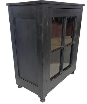 G905 Late 18th century Pennsylvania tabletop Cupboard, in early old black paint featuring a single door with four original wavy window lights, resting on a simple turned ball foot. The door is full mortised and pinned, the interior has a single shelf mortised into the panel. The back of the cupboard consists of two wide boards.  All rose head and square nailed construction. The wood is cherry.  Measurements:   14 ¼� deep x 25� wide x 30 ¾� tall