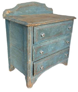 **SOLD** F759 Late 19th century Pennsylvania miniature childs chest of drawers boasting original blue painted surface with delicate red pinstriping and original knobs. Chest bears three drawers with mortised drawer stretchers and rests on a decorative cut out apron along front and shaped feet.  Tall backsplash with molded edge around top and backsplash. The wood is pine with small wire nail construction. Circa 1880. Measurements:  16 ¼ wide x 9 deep x 17 ½ tall (back) x 14 ¾ tall (front)