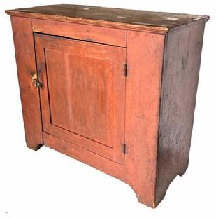 **SOLD** H173 Early 19th century one door Storage Cupboard in original bittersweet red paint. The top of the Cupboard is dovetailed with a single panel door which is mortised and pinned. Door opens to reveal a nice, clean interior with shelves. It has a nice high cut out foot. Original surface
