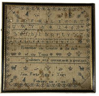 K285 Early 19th century identified and dated, hand-stitched sampler by Jane Forty Aged 9 years February the 9 184_.  A verse: Remember thy Creator in the days of thy youth * Godliness with contentment is great gain is stitched below the alphabet bands. Sampler is stitched with what appears to be cotton threads in blue and ecru/tan colors over linen material.  The top portion of the sampler features three bands of full alphabets and the numbers 1-8 with bands of various stitches separating the rows. Various versions of flowers, birds, animals, and crowns adorn the upper and lower field of the sampler. A nicely stitched border surrounds the sampler. Minor fabric loss in upper left quadrant, however the stitching remains remarkably preserved for its age. Wire on back for hanging purposes. Framed measurements are 12 ¾ wide x 3/8 thick x 12 ½ tall.   