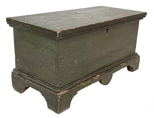 J221 Fantastic early 19th century miniature Pennsylvania blanket chest with dovetailed case and applied dovetailed bracket base in the original green painted surface. The base features decorative cut out feet and a single hand-hewn drop scallop cutout in the center of the front of the base. Applied molding around the lid and base on three sides is secured with tiny square head nails. Clean, natural patina interior. Circa 1820�s. Measurements: 17 ¾� wide x 8 ¼� deep x 9� tall 