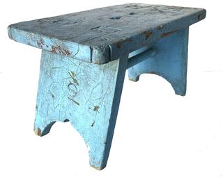**SOLD** H1001  Sturdy wooden stool retaining old blue painted surface. Canted legs are mortised through the top and are reinforced with a thick wooden dowel that supports the splayed legs. Unusual finger hole cut outs in center of top. Found in Pennsylvania. Measurements: 21 ½� wide x 11 ¾� deep x 12 ¼� tall.  The top and legs are 1 ¼� thick.