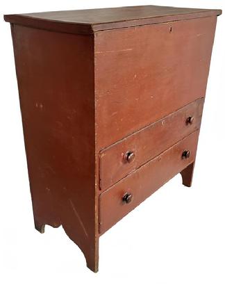 H1080 19th century New England original red painted mule chest featuring hinged lift lid storage area over two dovetailed drawers resting on tall cut out ends. Mortised battens on the underside ends of lid.  Square head nail construction. Natural patina interior.