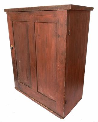 G319  19th century original red painted  hanging Cupboard, with  two panel door with a divider interior one board construction with square head nails  Measurements are 22 1/2' wide x 27" tall x 11 1/4" deep