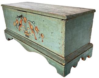 H334 Late 18th century to early 19th century Pennsylvania Miniature Blanket Chest with applied bracket base with beautiful Chippendale style designed foot and original spurs on ends, and original dropped apron front on the base. Retains original robin egg blue paint. Beautiful painted love birds with hearts on their wings, pinstriping and tulip decorations enhance the beauty of this piece. The paint decoration is typical of the Lancaster County, Pennsylvania area. The wood is white pine. The case is dovetailed, there are small tee nails and common cut nails in the bracket base. Chest retains original lock and hinges. Circa 1790 - 1810. Measurements: 17 1/2" deep x 19 3/4" wide x 8 1/2" tall.