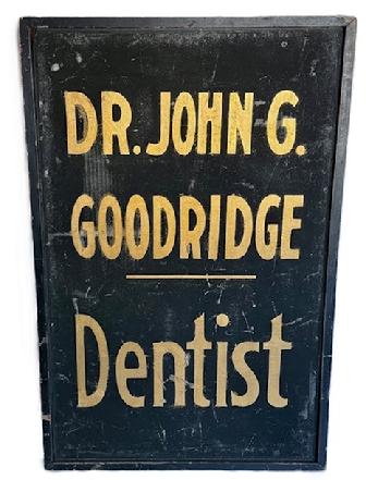 K1866 Single sided wooden Trade Sign that reads: "Dr. John G. Goodridge - Dentist". The lettering is hand painted in gold gild on a black sand-painted background with applied black painted molding surrounding all sides. Circa 1900.