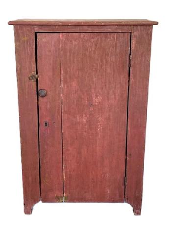 K1614 Mid 19th century Maryland one door storage cupboard bearing original red painted surface resting on high cut out feet. Square head nail construction. Clean natural patina interior with shelves for added storage options. The wood is pine. Circa 1850s. Measurements:  32 ½ wide x 18 deep x 49 tall.   