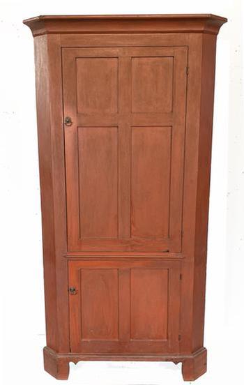 **SOLD** H1037 Late 18th century � early 19th century Pennsylvania original red painted corner cupboard with a tall, four panel door over a smaller, two panel door configuration. Doors are fully mortised and feature beaded edges. Top doors open to reveal decoratively shaped / butterfly shelves painted a  white