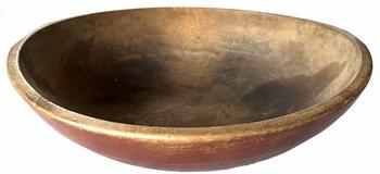Late 18th century wooden bowl in beautiful worn, dry original red paint. Hand turned out of round with wide band around the top. Very unique flattened edge on opposite sides of the top opening that appear to have been created/used for propping the bowl steadily on its edge to scrape contents from inside the bowl. Natural patina interior reflects wear chop marks and cracks indicative of age and use. Out of round at 16 1/2" X 17 1/4 " diameter x 5� deep.