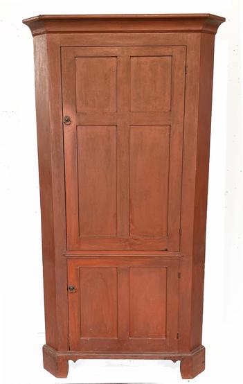 H1037 Late 18th century � early 19th century Pennsylvania original red painted corner cupboard with a tall, four panel door over a smaller, two panel door configuration. Doors are fully mortised and feature beaded edges. Top doors open to reveal decoratively shaped / butterfly shelves painted a  white