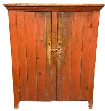 L192 Nice, early 19th century Lehigh Valley, Pennsylvania two door storage cupboard bearing its original bittersweet red painted surface. Cupboard features a dovetailed case with applied cornice molding and cut out feet. Natural patina interior with shelves for added storage options. The wood is pine with square head nail construction. Circa 1840s. Measurements: 49 &frac12;� wide x 19 &frac34;� deep x 59 &frac14;� tall.   