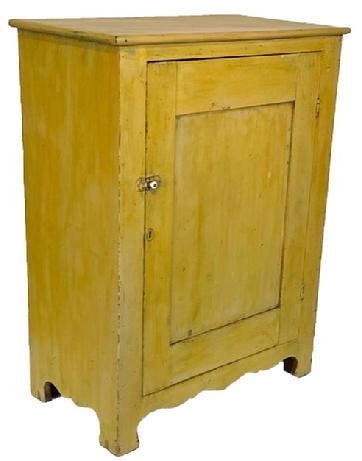 J15 Early 19th century Lancaster Co. Pennsylvania one door storage cupboard retaining its original yellow painted surface. The Cupboard has a single panel door which is  fully mortised,   solid ends with a nice high design cut out The front has a decorative cut out feet.  The back  board are held in place with Square head nail . Clean, natural interior. Measurements: 31 ¾� wide x 17 ½� deep x 42 ¼� tall