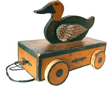 BF1 (H58) Late 19th century Painted Wood Duck Pull Toy with beautiful colors of pumpkin and green and black. The   Wings flap up and down when the Duck is pulled forward. It is mounted on a wooden base with wooden wheels in working condition. Measurements: 12"h. x 16"l. x 8"d.