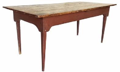 H502 � Mid 19th century Lancaster County, Pennsylvania unique farm table in original red painted surface. Unusual, shaped apron with chamfered corners applied to tapered legs. Hand hewn marks are visible on underside. Square head nail construction.