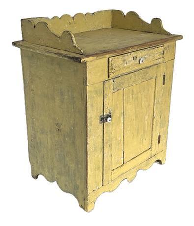 K158 19th century Pennsylvania original yellow painted Wash Stand with one drawer over one door configuration with an applied scalloped gallery on top resting on a decoratively cut out apron / ends. Square head nail construction with dovetailed gallery and mortised panel door. Clean, natural patina interior with shelves for additional storage. The wood is pine. Circa 1860s-1870s.  Measurements: 28� wide x 18� deep x 32 &frac12;� tall (back, with gallery) x 28 &frac12;� tall (front).  