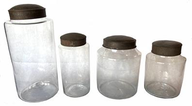(W47, K1229, W46) 19th century Set of four Jars Hand Blown with the original Tin Lids -These jars are Hand Blown Glass and were used in an Apothecary Shop. Circa 1830s. Impressive in size standing 11 1/2 tall for the tallest and 7" is the smallest 