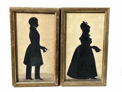 G720 Pair of early 19th century identified and dated, framed silhouettes with embossed maker�s marks. Each silhouette is framed with glass in both front and back, with �peek-a-boo� cutouts on the back showing the identity of the subject as well as the date. The Lady is identified as �Mrs. Sheppard 1831� and the Gentleman is identified as �Mr. J Sherwin 1831�. The matching frames are wooden and are gold gilded on the front sides only. Frames show wear indicative of age. Embossed maker�s marks are visible in the top corner of each silhouette, with the lady�s being in the upper left corner and reads �Dobbs & Co.� the Gentleman�s is in the upper right corner, however only the words �London B�� is decipherable. Framed measurements: 11 3/4� tall x 7� wide. 