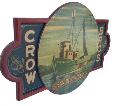 G729 Trade Sign advertising �Crow Bros.� �San Diego Fleet� with a large, raised circular center featuring a painting of a fishing/shrimp vessel named �Mike�s Place�. Each of the squared corners are accentuated with a painted star and each of the rounded portions on the ends of the sign showcase a very detailed painted anchor with rope. The sign boasts molded-border edges on all sides, including the center circle, with the outer edges being applied molding. The vibrant paint colors, spectacular lettering and pin striping details add to the overall appeal! This mid-20th century Trade Sign was made to look like those of the early 1900s. Very sturdy and heavy. Measurements: 57 1/2� wide x 35� tall x 1 1/2� thick.