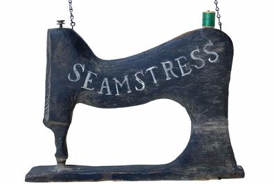 G901 Wooden two-sided Trade Sign (Tailor and Seamstress) in the form of a Sewing machine with original iron bracket and chain. Measurements: 22" tall (with bracket) 16 1/2" wide x 1 1/2" deep