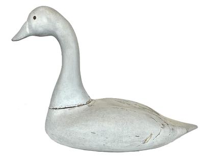 K115 Maryland Swan decoy - bearing second coat of working paint and tack eyes. Unknown carver. Heavy, solid wood - with evidence of water use / damage on bottom. Traces of rig initials (unreadable) painted in black on bottom. Approximate measurements: ~22 1/2" long (from tip of bill to tip of tail) x ~10" wide x ~15 1/2" tall    