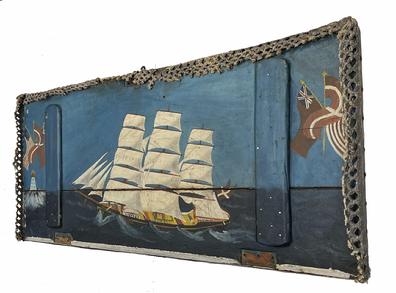 **SOLD** RM1430 Nautical painting of a ship bearing several flags � painted on the inside of a lid from an old sea chest. A very thick painted canvas material covers the back and extends beyond the edges of three sides. The canvas is secured with rounded-top copper tacks on three edges and wire nails on the fourth edge. The threads of extended canvas sections have been separated, meticulously �tatted� in a symmetrical pattern and heavily painted to create the look of a knotted rope frame around three sides. Great piece of nautical Americana. Measurements:  38 ¾� wide x 16 ½� tall.