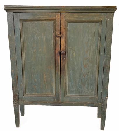 G197 19th century Shenandoah Valley, Virginia two door original blue painted cupboard resting on raised legs. Very unusual, shallow design boasting molding-framed inset panel ends and doors. Molding surrounds the underside of the top. Sides are mortised through the legs at the bottom. Doors open to reveal a clean, natural patina interior with several shelves for storage. Circa 1850s. Measurements: 42 ½� wide x 13 3/4� deep (top) x 53 1/4� tall (Case is 12 3/8� deep and internal shelves are 10 ½� deep) 