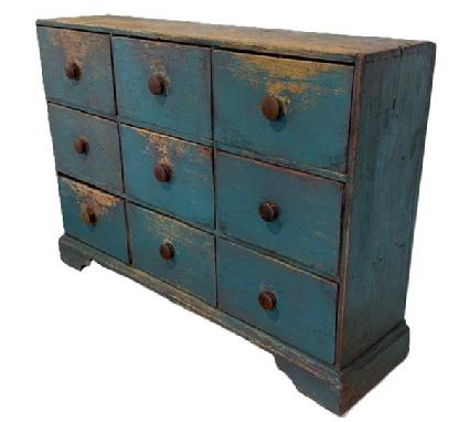 **SOLD** M2 18th century Pennsylvania nine (9) drawer apothecary with applied bracket base bearing old blue painted surface. Dovetailed case and dovetailed drawers. Four of the drawers retain mortised divided interiors. The wood is pine with a combination of T, rosehead and square head nail construction. Circa 1790-1810. Base measures: 50 ¼ wide x 13 deep. The case is 48 ¼ wide x 12 ¼ deep. Overall height Is 33 ¾ tall.