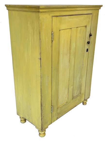 H467 � Exceptional 19th century Pennsylvania one door storage cupboard with original vibrant yellow paint resting on applied turned feet. Double panel door is fully mortised and pegged. Square head nail construction. Clean, natural patina interior with sturdy shelves for storage. Measurements: 37 ¾� wide x 17 ¾� deep x 50 ½� tall