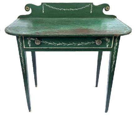 L127 19th century Country Hepplewhite Dressing Table bearing original green painted and white decorated surface featuring a scrolled backsplash and wide, dovetailed drawer and resting on tall gracefully tapered Hepplewhite legs. The wood is pine and it is constructed with wooden pegs and cut nails. Measurements: 36 wide x 19 deep x 34 ¾ tall (back) x 29 ½ tall (front). Clearance from apron to floor is 23 ¾.