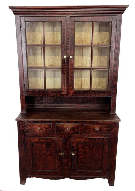 H325 Bold early 19th century Western Pennsylvania red and black paint decorated stepback cupboard with two, six-pane doors on the top, a tall open pie shelf and three drawers over two panel doors on the base. Nice original wavy glass, detailed molding around the top and crisp beaded edge around doors, drawers and pie shelf opening. Doors are full mortised and pegged. Circa 1820 - 1840s. Measurements: Base is 48 ¼� wide x 20 ¾� deep. Top is 51� wide across top molding x 13� deep. Top case is 11� deep. Overall height is 83� tall.