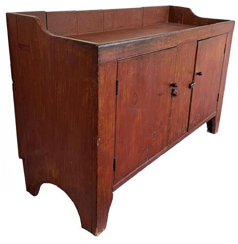 J380 Mid 19th century Pennsylvania original red painted dry sink featuring tall cut out feet and half-moon cut out ends, mortised well with shaped ends, and beaded edges around the doors. Clean, natural patina interior. Square head nail construction. Measurements: 56" wide x 21" deep x 35 ¾ tall (back) x 33 ½ tall (front)