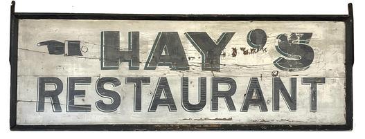 J446 Fantastic double sided wooden trade sign advertising Hays Restaurant with a painted hand pointing the direction. The lettering and directional on each side is hand painted in original black paint with green highlighting / shadowing on a white background. Sign is nicely framed with an applied molding that boasts a black painted surface. The original forged iron brackets remain intact on the top sides. (Later eye hooks on the top edge allow for versatility of hanging options.) Measurements: 58 ¼ wide x 1 ½ deep x 20 tall. 