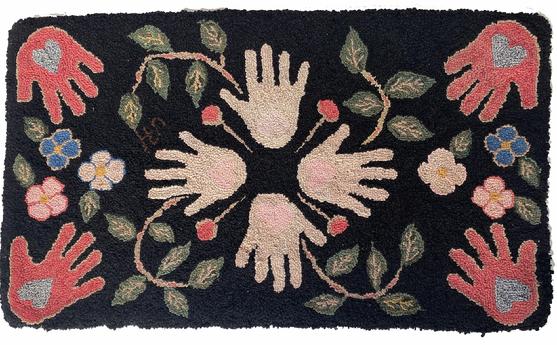 G748 Identified, late 19th century New England hand-hooked rug with �Heart in Hand� pattern arranged into a wreath with vines, leaves and floral accents in the center and a hand/heart in each corner. The initials �JH� are hooked at the end of one of the vines/leaves.  Vibrant colors are arranged in a visually appealing layout in a black background. Wool, and possibly some cotton, hooked on burlap with a cotton sleeve hand stitched to the back for hanging. There are also squares of burlap hand stitched on the back to reinforce the hearts in the center hands as seen in photos. Measurements: 38� wide x 22� tall