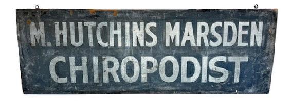 H933 19th century Adverting Sign for “M. HUTCHINS MARSDEN” “CHIROPODIST” in white lettering on a dark blue sand painted background. The double-sided sign is painted on a single board with one side having slightly molded edges. Two early iron eye hooks remain intact on the top edge of the sign for hanging purposes. Measurements: 40 ¼” wide x ~7/8” thick x 13 ¾” tall.