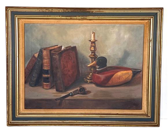 H91 Framed Oil painting on canvas featuring a still life of a book, candlestick, pipe and decoy. Signed in lower right hand corner 'Ella Ruark'. Artist's card is stapled to back - indicating it was from Baltimore, Maryland. Framed measurements: 30 1/4" wide x 24" tall x 1 5/8" thick. NOTE: Ella Ruark (1915 - 2015) was born in Hooper's Island, Maryland in 1915, graduated from Hooper's Island High School in 1932 and moved to Baltimore with her husband in the 1940's. She began her career at the local YMCA then attended the Schuler School of Fine Arts where she transformed her painting hobby into a career. She had a painting chosen by the Grand National Waterfowl Association in 1993. She passed away on May 11th, 2015 at the age of 99 years old.