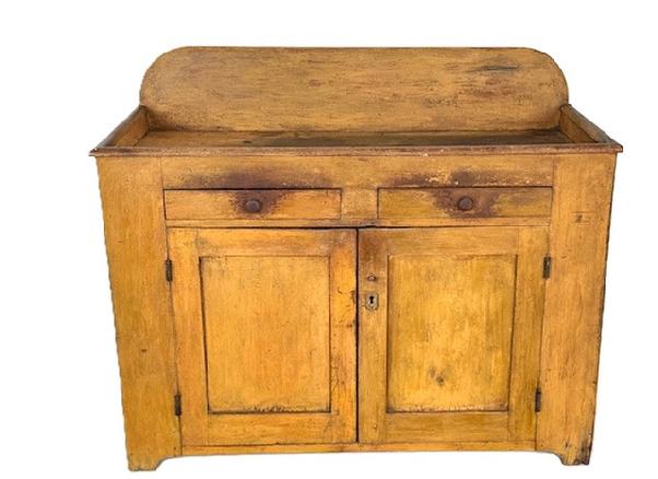 J432 Mid-19th century Pennsylvania dry sink in original mustard paint featuring an open well with backsplash over two dovetailed drawers over two fully mortised and pegged doors. Applied molding around front and sides of open well. Natural patina interior. Pine wood with square head nail construction. Circa 1840 -1850. Measurements: 46 ¾ wide x 21 deep x 32 tall (front) x 38 tall (back).   