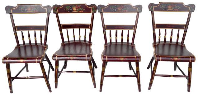  F305 19th century Set of four paint decorated plank seat chairs, each with a rectangular rolled crest rail with half spindle back and shaped plank seat. The cylindrical tapered legs are splayed with a stretcher. The splat, slat and seat rail are decorated with painted fruit and floral design all on a brown  ground with gold highlights Pennsylvania, circa 1850-1860.