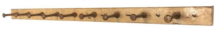 G247 19th century Pennslyvania Peg Rack with nine wooden hand carved mortised wooden pegs, and five small metal hooks, the original mustard paint, the back board is 1 1/2 " thick, with and Ogee molded edge. circa 1800-1820
