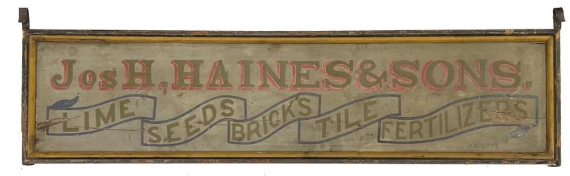 **Sold**H276 Exceptional double sided large wooden Trade sign from Medford, Burlington County, New Jersey �Jos. H. Haines & Sons� One side advertises �Coal, Lumber, Hay, Straw, Machinery��the opposite side advertises �Lime, Seeds, Bricks, Tile, Fertilizers�. Both sides are signed �J.S. Hays� in the lower right corner. The proprietor�s name is painted in bold gold painted letters with red highlighting on one side and blue highlighting on the opposite side. Each of the items advertised is creatively painted to appear as if they are inside sections of a wavy banner across the bottom of the sign. The lettering is done in gold paint and the outline of the banner is red on one side and blue on the opposite side. A nice, double molded edge surrounds each side of the sign. The Jos H Haines & Sons business was located on Tidswell Avenue in Medford, New Jersey and was known as a major distributor of coal and lumber. This sign shows great workmanship and wear indicative of age.  Measurements: 80� long x 20� tall x 3� thick. Iron brackets are 23 ½� tall and 1 1/8� wide.