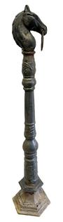 M1137 19th century cast iron Hitching Post on its original post from an estate in Chestertown MD.  upright fixture with a top ring for tying horses, often ornately designed and made by foundries during the height of horse drawn transport. In the 1800s, hitching posts were essential for securing horses in front of homes, inns, churches, and public buildings. oxidation with remnants of early black painted surface. Overall height is 53 &frac14;� tall, with the portion that would be seen once base is buried, being 46 &frac12;� tall. The head measures: 8� deep x 4 3/8� wide x 9 &frac14;� tall. 