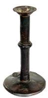 L372F Early 19th century Wedding band hog scraper candle stick with remnants of maker's stamp on the working push-up tab. Sheet iron construction with wedding band. No evidence of ever having a finger curl. Base has break along the edge. Surface patina indicative of age and use. Measurements: 4" diameter base x 7 ½ tall.